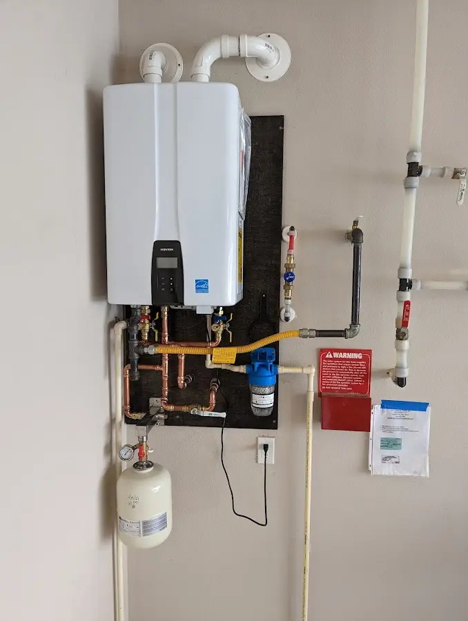 Professional plumber installing copper piping in a Holmen home